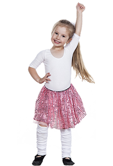 Mała tancerka: 5-letnia dziewczynka w białych getrach, różowej spódniczce z cekinami i białym body, stojąca na dwóch nogach z lewą ręką uniesioną nad głową i prawą ręką opartą o bok, szeroko się uśmiechając, z długimi włosami związanymi w koński ogon